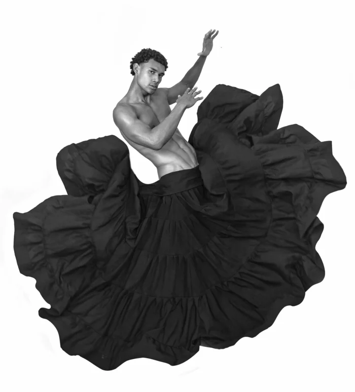 Un bailarín se apropia de una falda huracanada, mostrando sensualidad y fuerza.